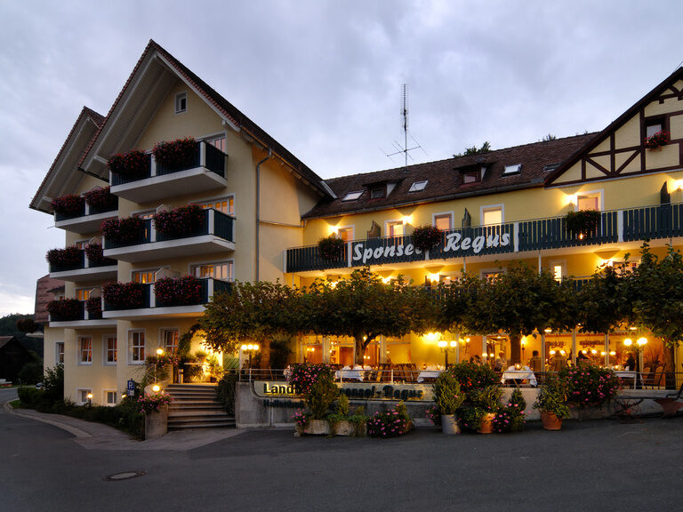 Die Aussenansicht des Hotels Sponsel-Regus in Franken bei Dämmerung mit beleuchteter Fassade
