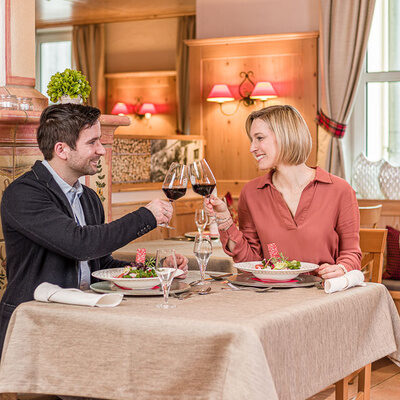 Ein Mann und eine Frau sitzen an einem Tisch im Hotel Sponsel-Regus in Franken und stossen mit einem Glas Wein an