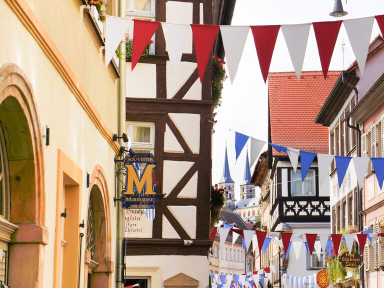Eine historische Gasse in einer Stadt in Franken mit Fahnen geschmückt