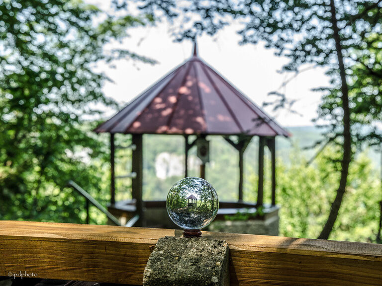 Ein stiller Augenblick: Glaskugel auf einem Holztisch in einem Pavillon.