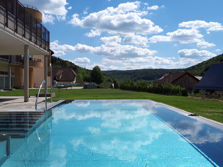 Der große Aussenswimmingpool des Hotels Sponsel-Regus in Franken an einem sonnigen Tag