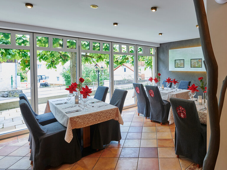 Ein gemütlicher Essbereich mit Tischen und Stühlen im lichtdurchfluteten Restaurant des Hotels Sponsel-Regus