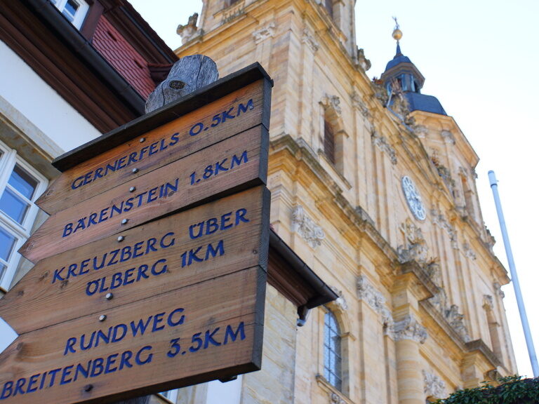 Holzschilder mit Wegbeschreibungen in Front der Basilika Gößweinstein in Franken